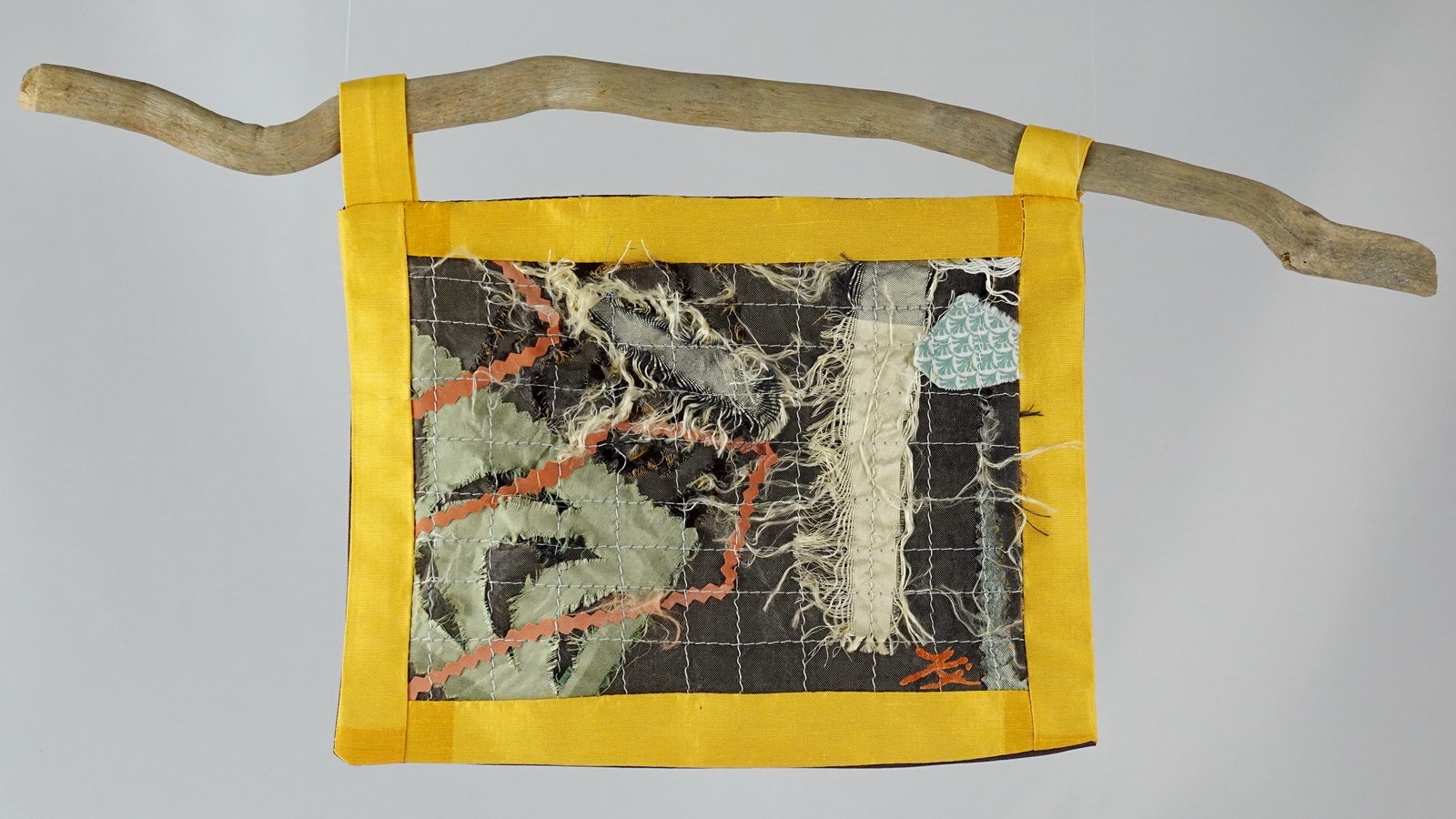 Œuvre textile suspendue en patchwork artistique sur support en bois flotté, mélange de soie, coton et fils apparents, inspirée du boro japonais et du wabi-sabi